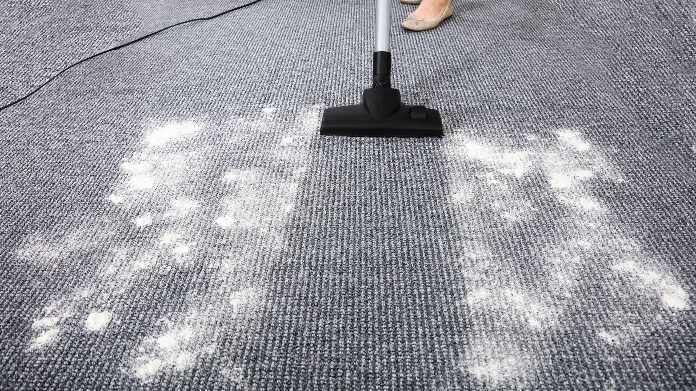 a person vacuuming carpet with a vacuum cleaner