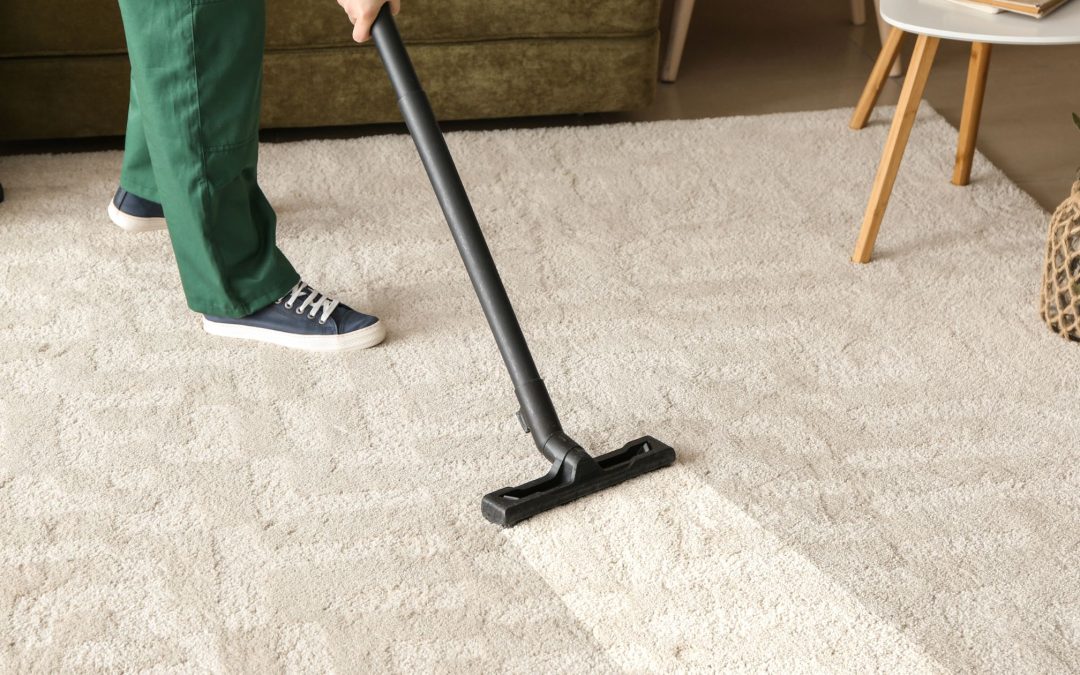 a person vacuuming carpet with a vacuum cleaner