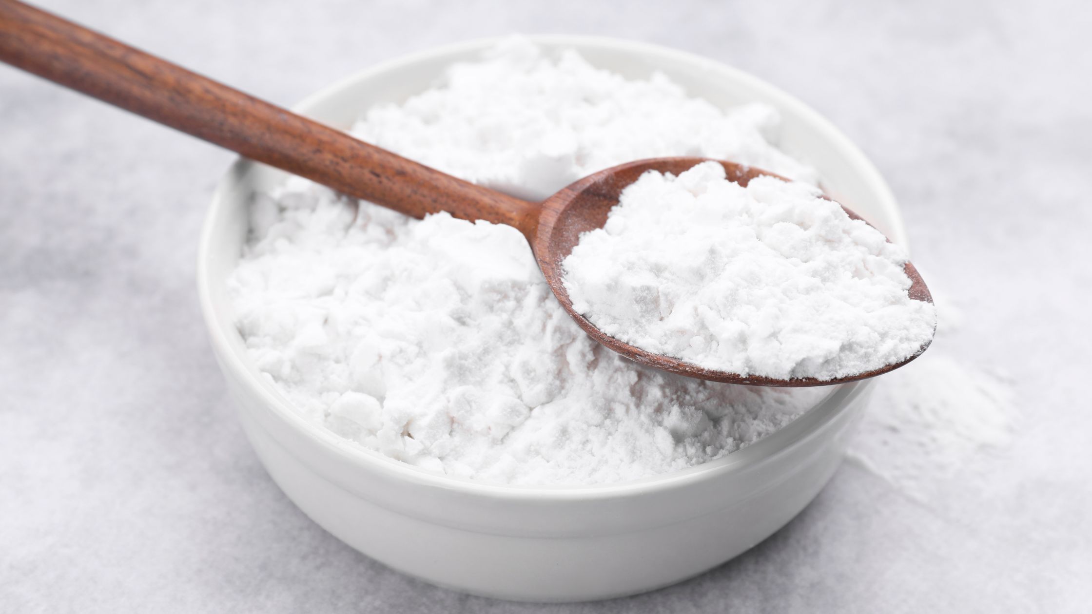 a bowl of powdered sugar with a wooden spoon