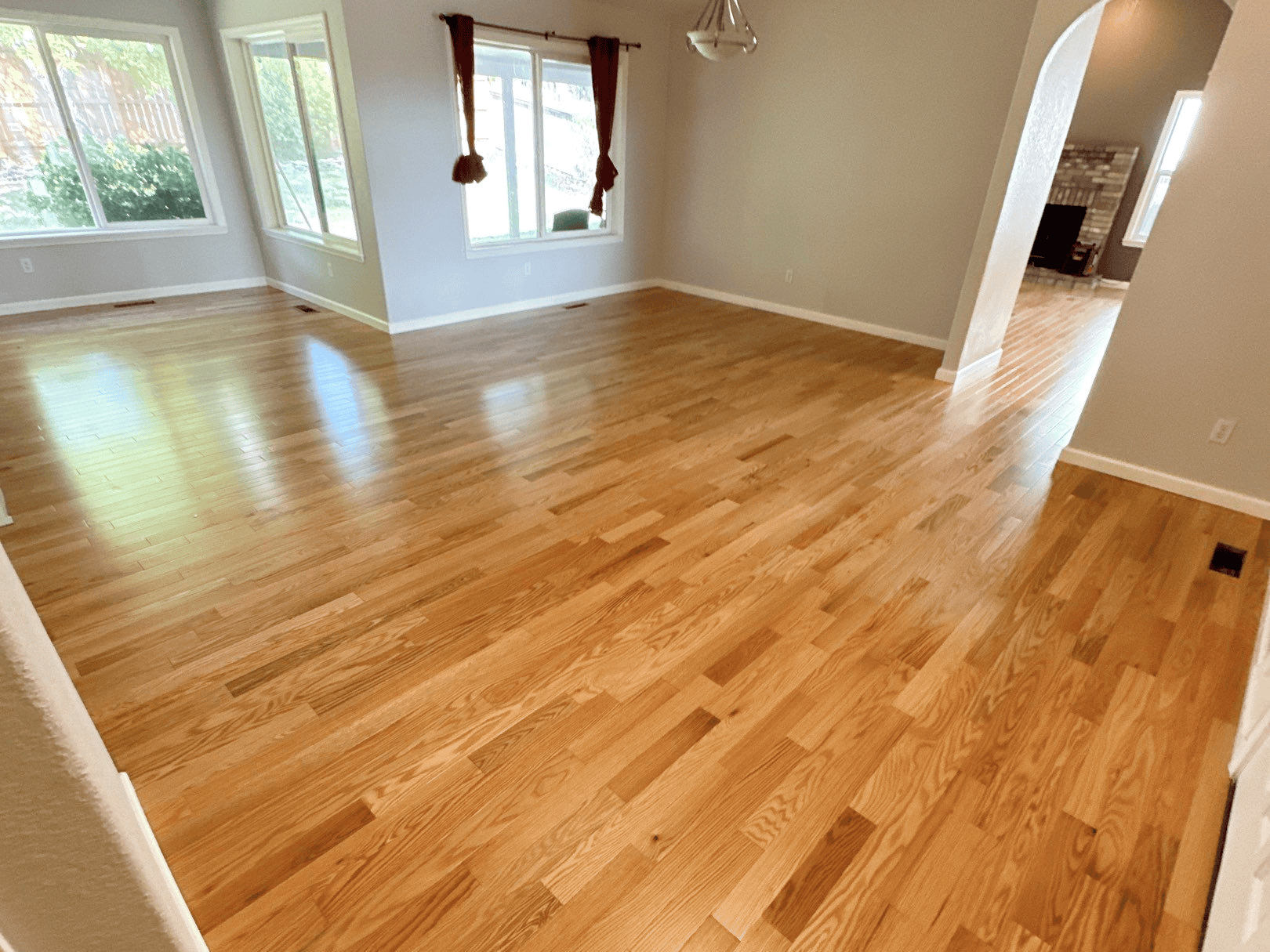 Beautiful hardwood flooring installed in a bright, spacious living room. Perfect for enhancing home.