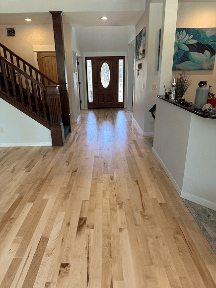 Beautiful natural wood flooring installed in a modern home entryway.