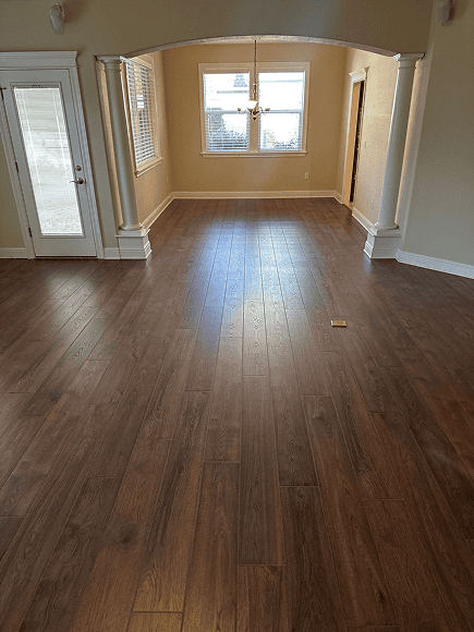 Hardwood floor in a bright, spacious living room with large windows and natural light.